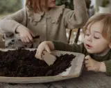 Two children planting seeds in soil.