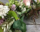 Vacker krans med vita och rosa blommor, gröna blad och ax. Någon har valt att binda krans med kärlek.