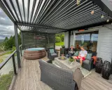 En härlig uteplats med spabad och sittgrupp under tak. Perfekt för avkoppling med en genomtänkt patio design.